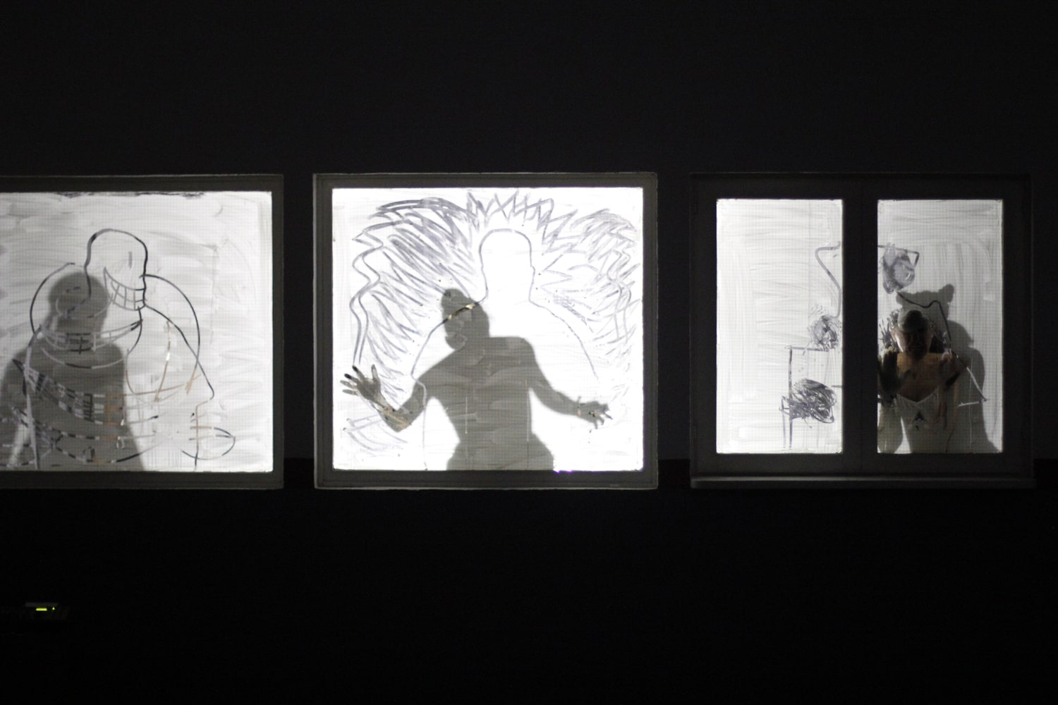 Shadows of three performers during Atrabilis by Salon de los Invisibles