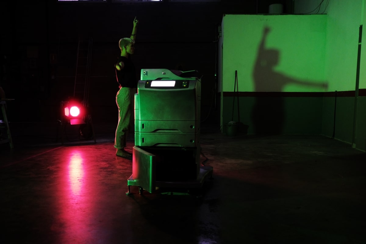 Shadow of performer playing with a printer in theatre show Omnia Vanitas